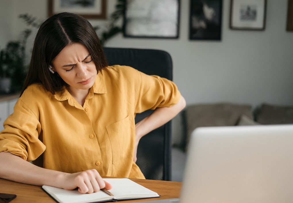 a woman suffering from back pain from poor posture